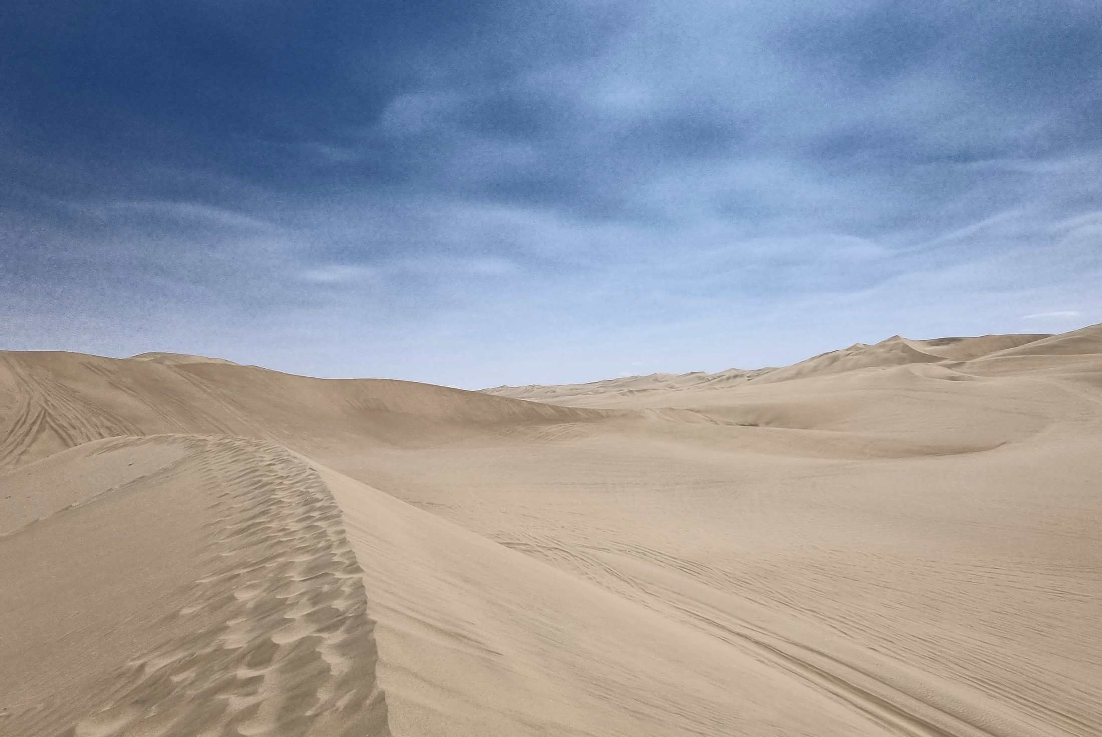 Empty sand dunes under a blue sky